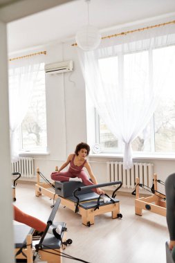 Pilates dersi sırasında spor yapan bir kadın..
