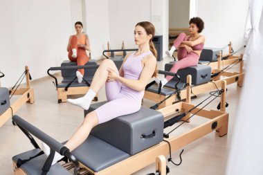 Spor salonunda dinamik bir pilates seansına katılan bir grup güzel kadın..