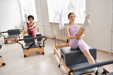 Spor salonundaki güzel kadınlar pilates dersi alıyorlar, güç ve esnekliğe odaklanıyorlar..