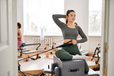 Çekici kadınlar pilates kursuna gider, esneklik ve çekirdek kuvvete odaklanırlar..