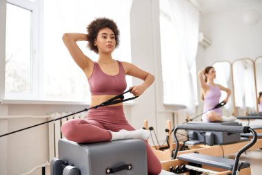 Güzel kadınlar pilates kursuna katılır, esneklik ve çekirdek kuvvetine odaklanırlar..
