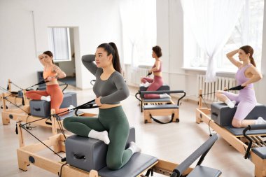 Bir grup sportif kadın birlikte pilates yapıyor..