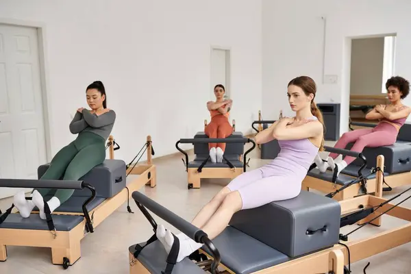 stock image A vibrant group of pretty sporty women engaged in a Pilates lesson in a room.