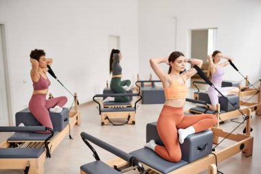 Spor salonunda pilates yapan bir grup sportif kadın..
