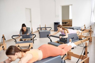 Parlak bir odada pilates yapan enerjik bir kadın grubu..