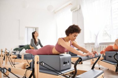 Spor salonunda pilates dersi sırasında spor yapan kadınlar..