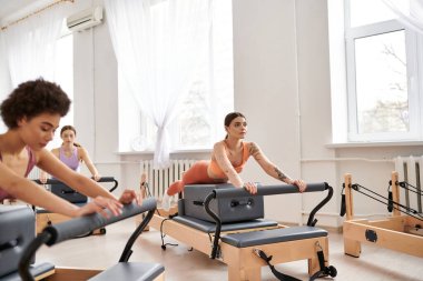 Spor giyim kuşamında, spor salonunda pilates yaparken kadınların ilgisini çekmek..