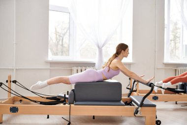 Pilates dersi sırasında egzersiz yapan zinde bir kadın..