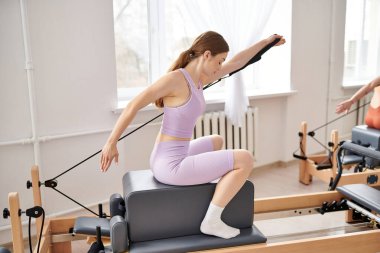 Aktif kadın pilates dersi sırasında egzersiz yapıyor..