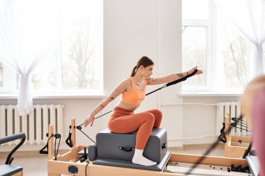 Spor giyimli güzel bir kadın pilates dersinde arkadaşıyla birlikte..
