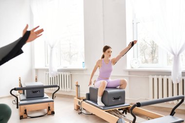 Spor kıyafetleri içinde spor salonunda pilates yaparken birlikte spor yapan kadınlar..