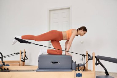 Pilates dersinde spor kıyafetli, formalı bir kadın..