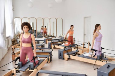 Bir grup güzel, sportif kadın bir spor salonunda birlikte duruyorlar..