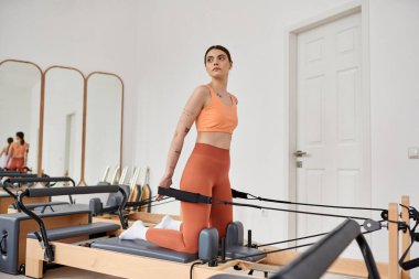 Rahat spor giyim içinde güzel bir kadın pilates dersinde pratik yapıyor..