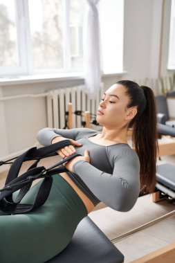Fit bir kadın pilates dersinde aktif olarak pratik yapıyor..