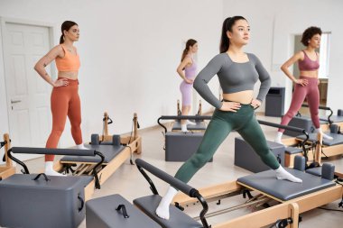 Bir grup sportif kadın pilates sınıfında egzersiz yapıyor..