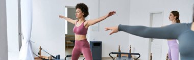 Bir grup güzel, sportif kadın dinlenme odasında pilates yapıyor..