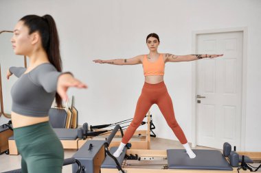 Genç kadınlar birlikte spor salonunda pilates yapıyorlar..