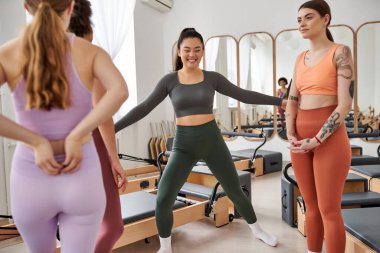 Güzel kadınlar pilates dersinde birlikte vakit geçirip rahatlıyorlar..