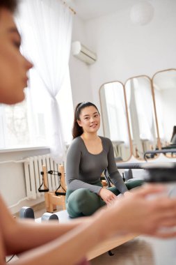 Güzel kadınlar pilates dersinde birlikte vakit geçirip rahatlıyorlar..