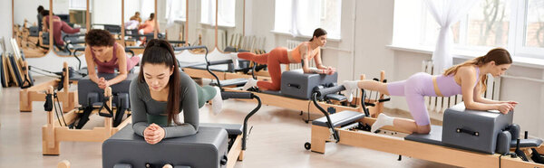 Alluring women in sportswear during pilates in a gym together.