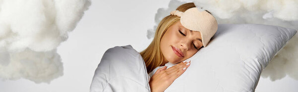 Блондинка в уютной пижаме мирно спит на подушке среди пушистых облаков.