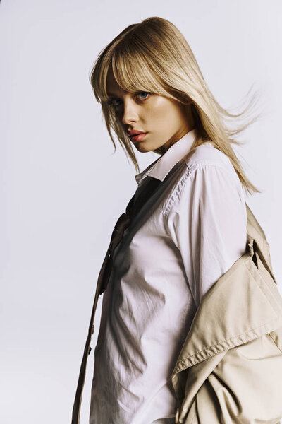 Стильная женщина в белой рубашке и черном галстуке, ставящая позу.