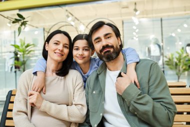 Neşeli bir aile markette alışverişin tadını çıkarırken bankta mola verir..