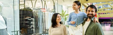 A cheerful family explores shops together in a bustling shopping mall on a weekend outing. clipart