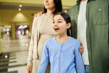 Mutlu bir aile hafta sonu alışveriş merkezinde kızıyla eğleniyor..