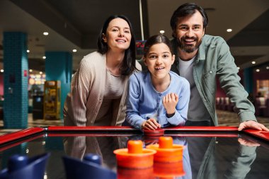 Mutlu bir aile hafta sonu atari salonunda bilardo oynarken güler ve dostça bir maçta yarışır..