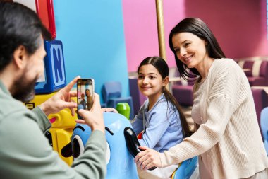 father captures a picture of her happy family exploring the toy store during a fun weekend outing. clipart