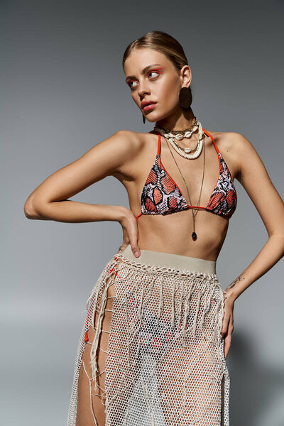 Blonde woman in bikini and skirt, striking a pose.