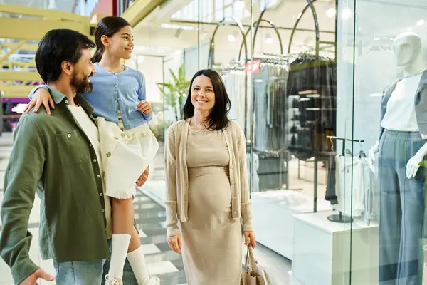 stock image A pregnant woman and her husband enjoy a shopping trip in a mall, selecting items for their new arrival.