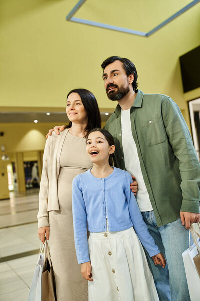 Family enjoying shopping spree, strolling through bustling mall with multiple shopping bags in tow.