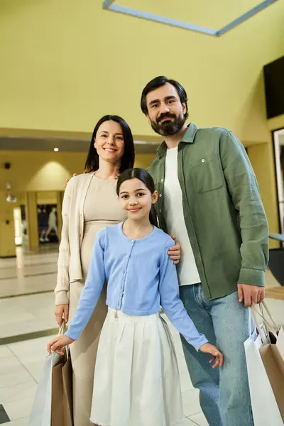 stock image A joyful family with shopping bags leisurely strolling through a bustling mall on a fun-filled weekend.