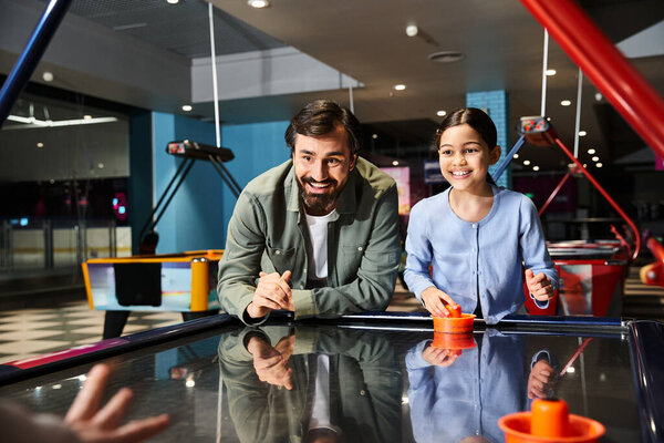 family joyfully compete in a game of air hockey at an arcade, immersed in a friendly rivalry.