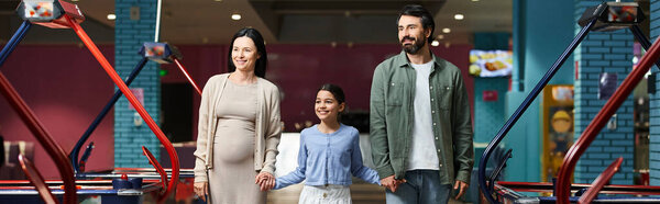 Cheerful family enjoys a day at the arcade, standing together in front of a colorful air hockey at the mall gaming zone.