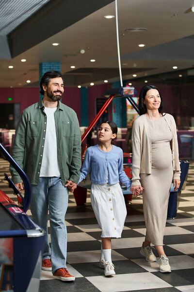 Счастливая семья, родители и ребенок, наслаждающиеся неторопливой прогулкой в выходные.