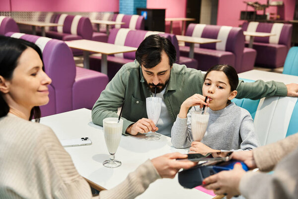 A joyful family enjoys time together at a stylish cafe, creating lasting memories during the weekend.