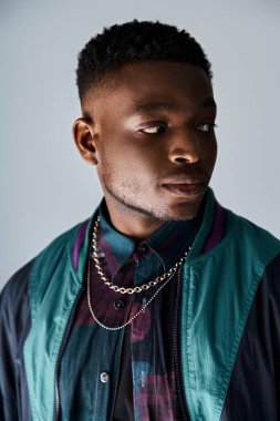 Yakışıklı Afrikalı Amerikalı adam şık bir ceket ve kolye giyiyor..