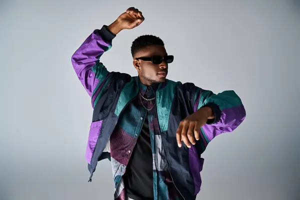 stock image Stylish African American man in purple jacket and sunglasses dancing energetically.