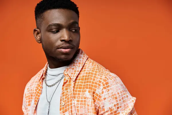 stock image Handsome man striking pose in trendy orange shirt.