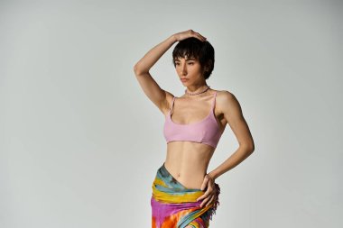 A beautiful young woman showcasing vibrant, swirling movements in a colorful skirt on a white background.