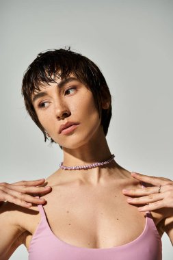 Young woman in pink top, exuding confidence.