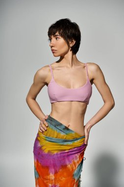 A young woman striking a pose in a stylish pink bikini.