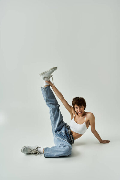 A woman energetically posing actively on a white backdrop.