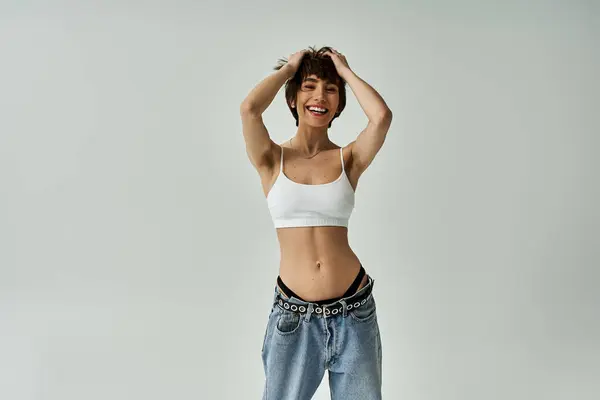 stock image Stylish young woman in white top and jeans striking a pose.