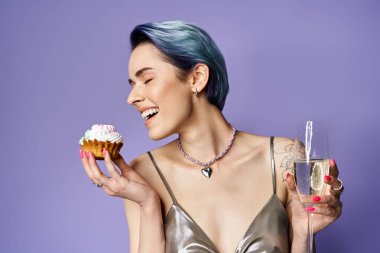 A stylish young woman with short blue hair holding a delicious cupcake and champagne glass