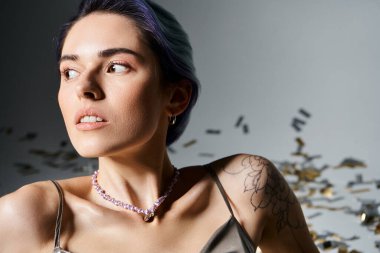 A stunning young woman with short blue hair wearing a silver party dress, a necklace